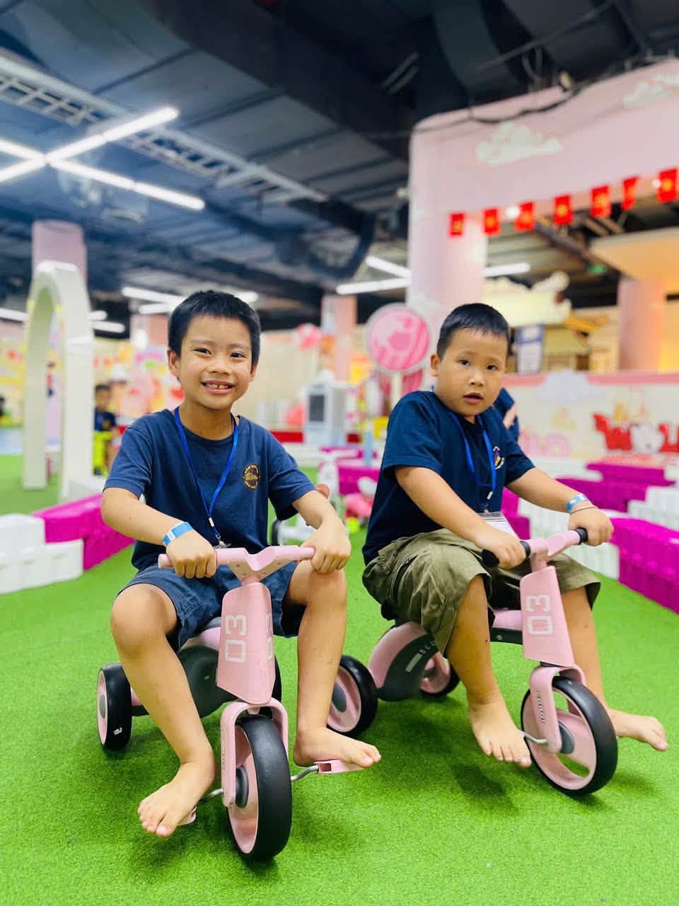 Hai bạn nhỏ Mầm non FBK chơi xe chòi chân ở khu vận động Wolfoo World